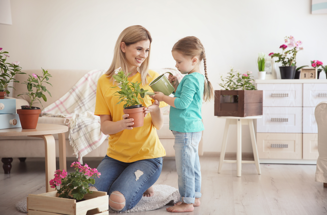 Mujer y niña regando planta y ahorrando agua