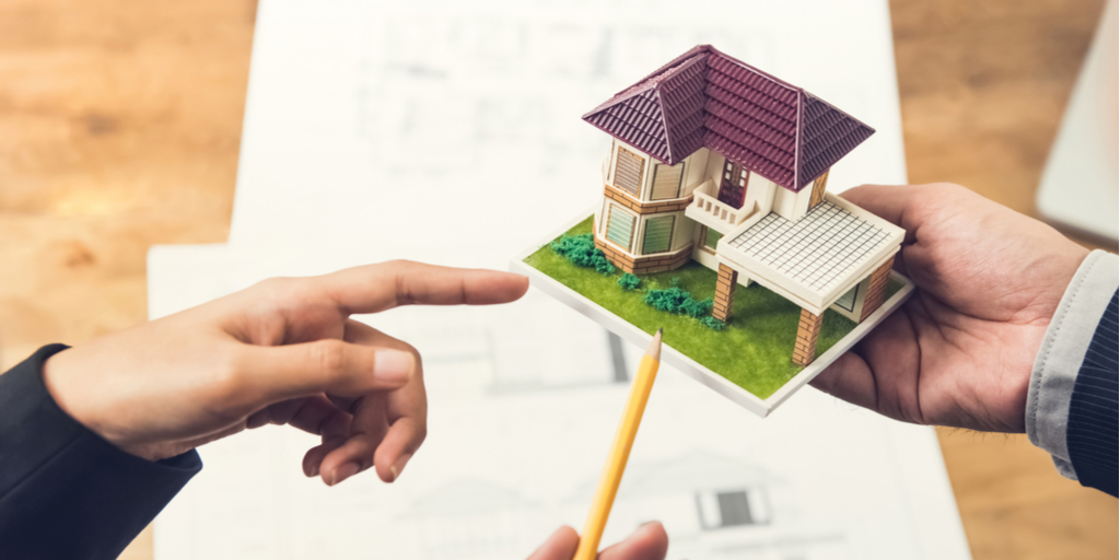 mano señala proyecto en sala de ventas